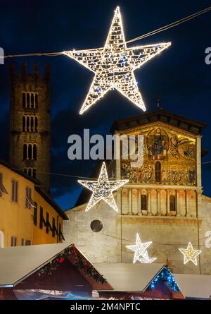 Christmas in Lucca. Christmas market with stars in front of St Frediano medieval church Stock Photo