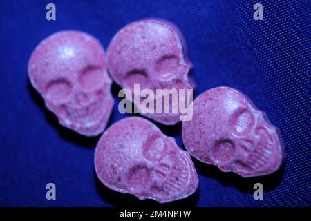 Pink skull ecstasy pill close up background high quality prints purple army dope narcotics substance high dose psychedelic way of life Stock Photo