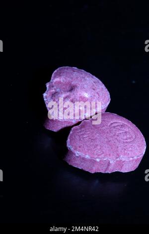 Pink skull ecstasy pill close up background high quality prints purple army dope narcotics substance high dose psychedelic way of life Stock Photo