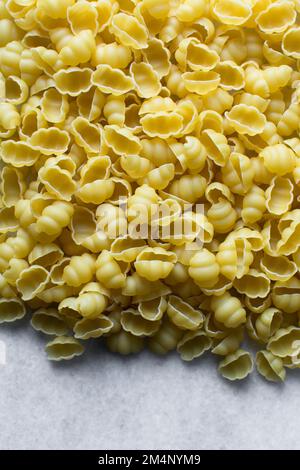 Flat lay of uncooked Gnocchetti pasta shells, top view of gnocchi pasta shells, dry uncooked macaroni Stock Photo