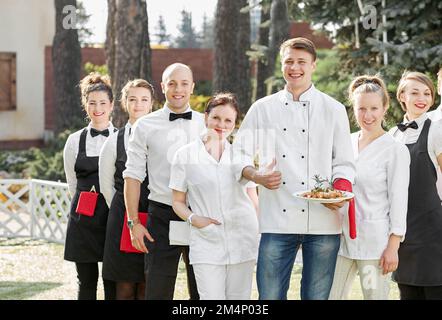 restaurant staff standing together and showing thumb up. Stock Photo