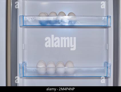 White eggs in rows in refrigerator boxes Stock Photo