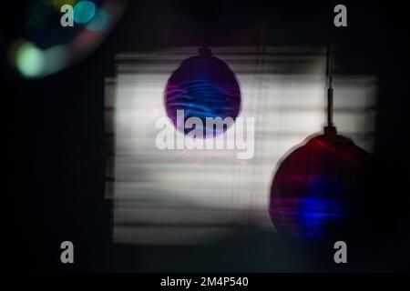 Glass hanging lights forming a colourful interesting shadow on a wall as the light shines through a window. Stock Photo