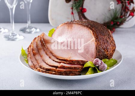 Christmas ham for celebration dinner, spiral sliced ham on a serving plate Stock Photo