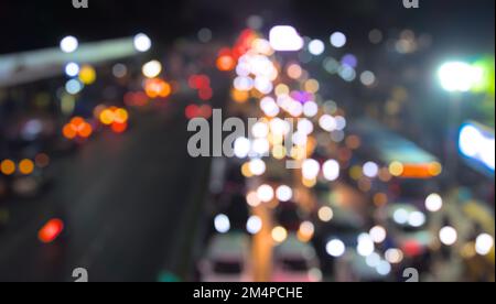 De-focused vehicles on traffic signal photo. Vehicle and other lights creating bokeh effect. Night, top down view. Stock Photo