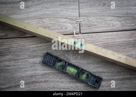 Spirit level tool or bubble levels at construction site. Laying ceramic tiles using plastic crosses. Stock Photo