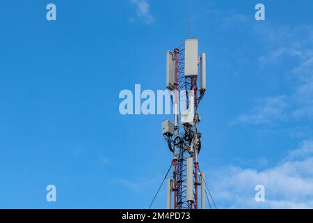 Mobile or cell tower with antennas and electronic equipments on blue sky. Broadband transmission technologies Stock Photo