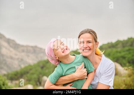 Nurse plays with her young cancer patient in the wilderness Stock Photo