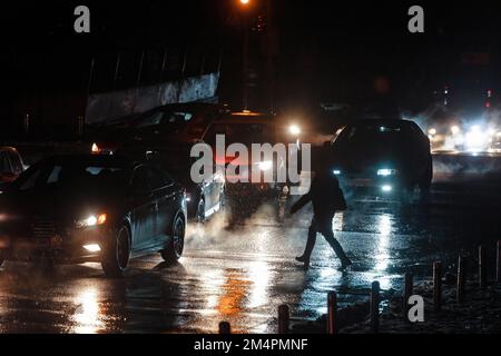 Kyiv, Ukraine. 16th Dec, 2022. Passers-by cross the street at a pedestrian crossing illuminated by car headlights. The streets of Ukraine's capital are shrouded in darkness and shadows now because of restrictions on the use of electricity. The lack of light creates moments of apprehension. That's the result of the rolling power outages Ukraine has put in place to prevent a complete collapse of the national energy grid, after repeated Russian bombardments. (Photo by Mikhail Palinchak/SOPA Images/Sipa USA) Credit: Sipa USA/Alamy Live News Stock Photo