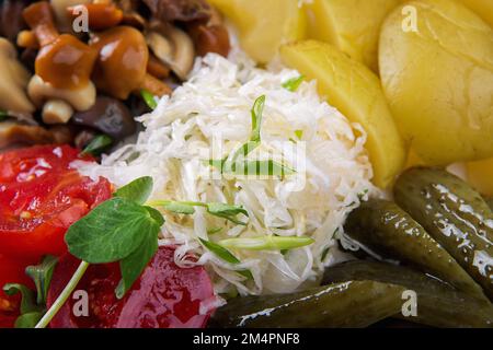 Pickled cabbage, cucumbers, tomatoes, apples and mushrooms close-up Stock Photo