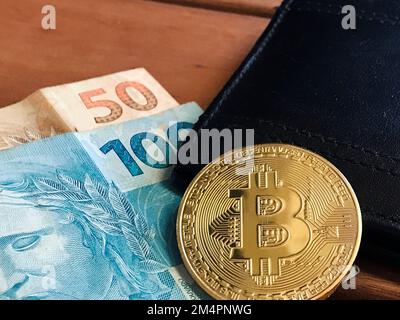 Bitcoin With Real Brazilian Money on Letter Wallet on Wooden Table. Space for text. Stock Photo