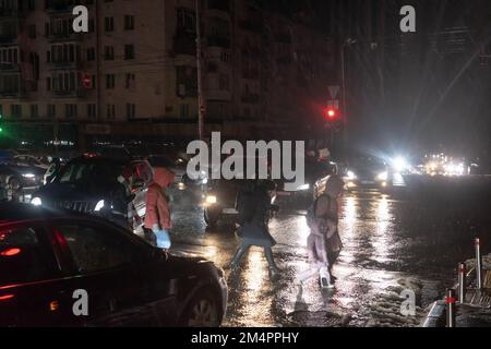 Kyiv, Ukraine. 16th Dec, 2022. Passers-by cross the street at a pedestrian crossing illuminated by car headlights. The streets of Ukraine's capital are shrouded in darkness and shadows now because of restrictions on the use of electricity. The lack of light creates moments of apprehension. That's the result of the rolling power outages Ukraine has put in place to prevent a complete collapse of the national energy grid, after repeated Russian bombardments. (Credit Image: © Mykhaylo Palinchak/SOPA Images via ZUMA Press Wire) Stock Photo