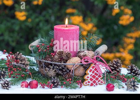 christmas decoration with red candle, cones and walnuts in basket Stock Photo