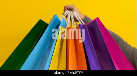 Close-up of a woman's hands holding colorful shopping bags Stock Photo