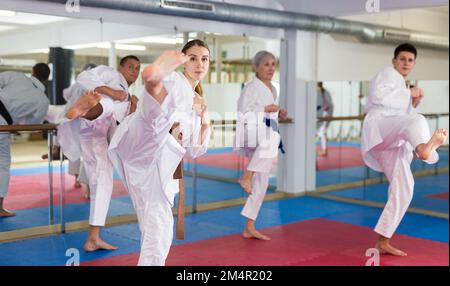 Men and women in kimono performing kata in gym during training Stock Photo