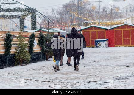 Kyiv, Ukraine - January, 2022: Christmas outdoor fair with Christmas tree, church, carousel and lights at the evening at snowy day. Festive holidays before war. Stock Photo