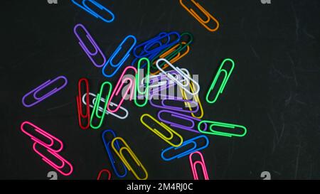 Colorful paper clips isolated on black background Stock Photo