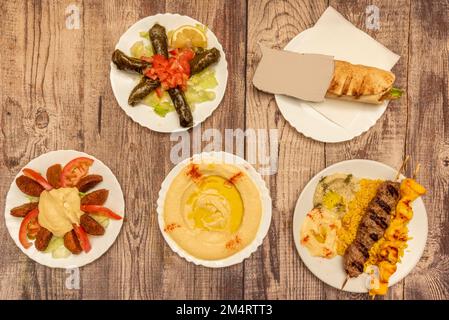 Set of dishes from super popular Middle Eastern food recipes with chickpea hummus with paprika and oil, stuffed vine dolmas, falafel fdrito, a shawarm Stock Photo
