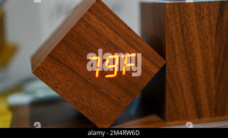 Digital room temperature gauge made of wood and red LED light indicating the temperature level is 79 fahrenheit Stock Photo