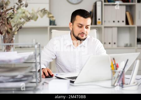 Male office manager using laptop computer Stock Photo