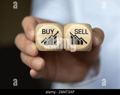 Dices cubes with the words SELL BUY on financial downtrend chart graph. Selective focus Stock Photo