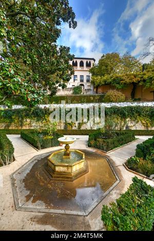 View of The Generalife courtyard, with its famous fountain and garden through an arch. Alhambra de Granada complex at Granada, Spain, Europe on a brig Stock Photo