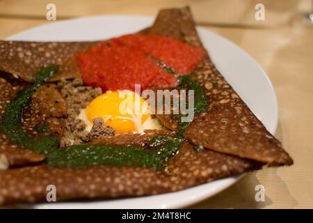 Galette Breton - Buckwheat Crepe with egg, ground beef, pesto and tomato sauce. Stock Photo