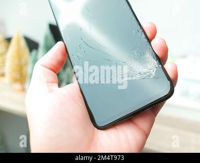 Smartphone with cracked screen in hand, object isolated Stock Photo