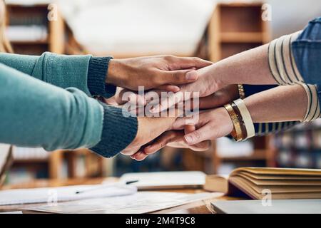 Heres to straight As. a group of students stacking their hands on top of each other. Stock Photo