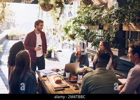 Discussing ideas over lunch. a group of creative workers having a meeting over lunch in a cafe. Stock Photo