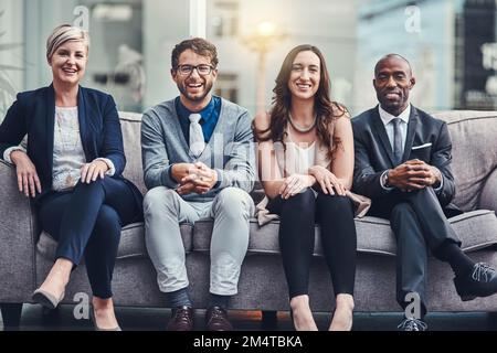 Were the team you need if you want to succeed. Cropped portrait of a group of businesspeople sitting on a couch in an office. Stock Photo