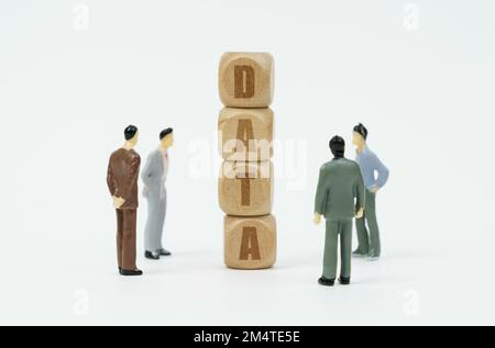 Business and finance concept. On a white background, figures of businessmen look at wooden cubes with the inscription - DATA Stock Photo
