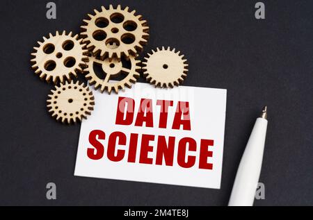 Industrial concept. On the black surface are gears, a pen and a business card with the inscription - DATA SCIENCE Stock Photo