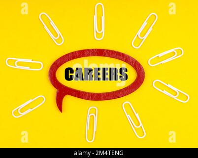 Business and economy concept. On the yellow surface are paper clips, and a plate inside which the inscription - Careers Stock Photo