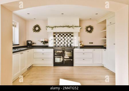 a kitchen with black and white checkered tiles on the walls, wood flooring and wooden floors in it Stock Photo