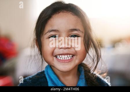 Turning into a big girl. Portrait of a cheerful little girl playing around at home while smiling all the way inside during the day. Stock Photo