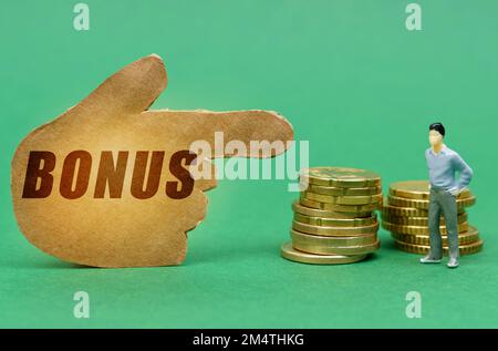 Business and economy concept. On the green surface of the coin and a figure of a man, they are indicated by a sign - a hand with the inscription - bon Stock Photo
