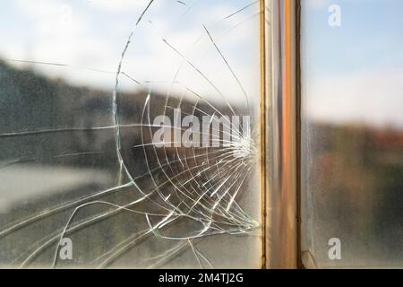 Dirty broken window glass with cracks from stone hit or beak from bird flying near creation Stock Photo