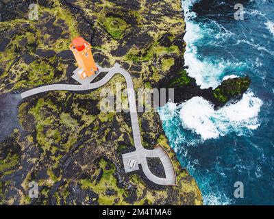 Top down aerial view of an orange Svortuloft Lighthouse in West Iceland by the sea Stock Photo
