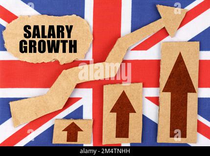 The concept of national statistics. On the flag of Great Britain, a growth chart and a cardboard plate with the inscription - Salary growth Stock Photo