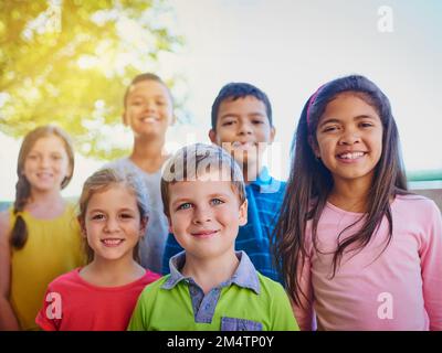 The fun never stops with this bunch. a diverse group of children outside. Stock Photo