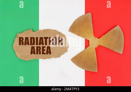 The concept of industry and radiation. On the flag of Italy, the symbol of radioactivity and torn cardboard with the inscription - Radiation Area Stock Photo