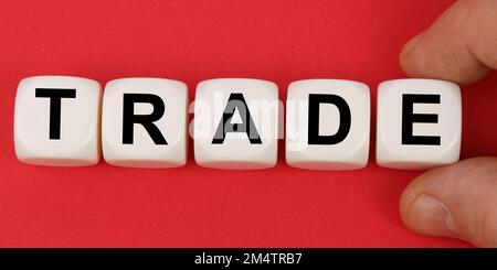 Business and finance. On the red surface, white cubes with the inscription - TRADE Stock Photo