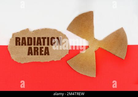 The concept of industry and radiation. On the flag of Poland, the symbol of radioactivity and torn cardboard with the inscription - Radiation Area Stock Photo