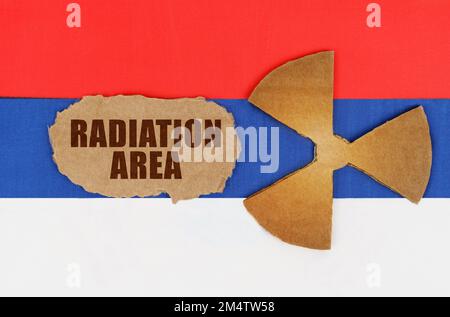 The concept of industry and radiation. On the flag of Russia, the symbol of radioactivity and torn cardboard with the inscription - Radiation Area Stock Photo