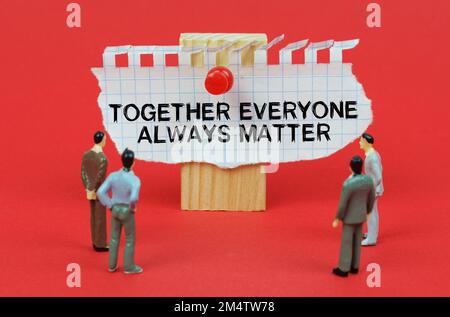 Business concept. On a red background are miniature figures of people looking at an ad with the inscription - Together Everyone Always Matter Stock Photo