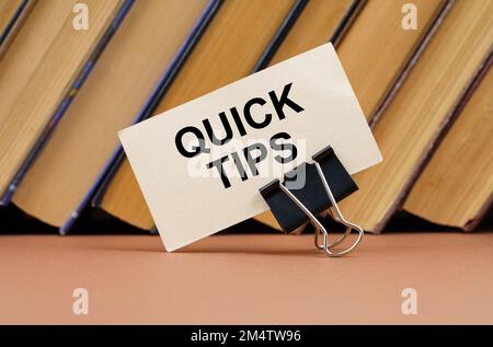 Education and science concept. On the table against the background of books is a business card with the inscription - QUICK TIPS Stock Photo