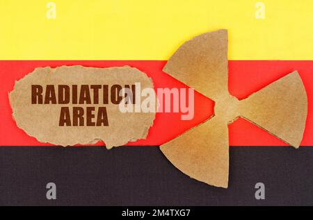 The concept of industry and radiation. On the flag of Germany, the symbol of radioactivity and torn cardboard with the inscription - Radiation Area Stock Photo