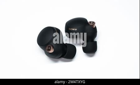 The Sony WF-1000XM4 truly wireless headphones on white background. Stock Photo