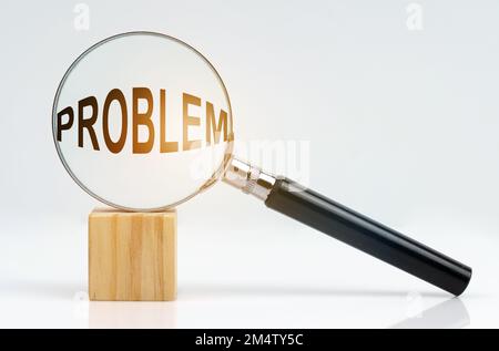 Economic concept. On a white surface there is a cube and a magnifying glass inside which is the inscription - problem Stock Photo